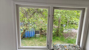 Una habitación con ventana que da a un jardín.