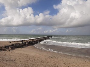 A beach with a rocky breakwater and waves. - 4 Star Holiday Home in Thyboron (Thyborøn)