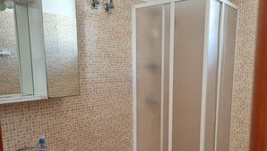 Een badkamer met wastafel, spiegel, toilet en douche.