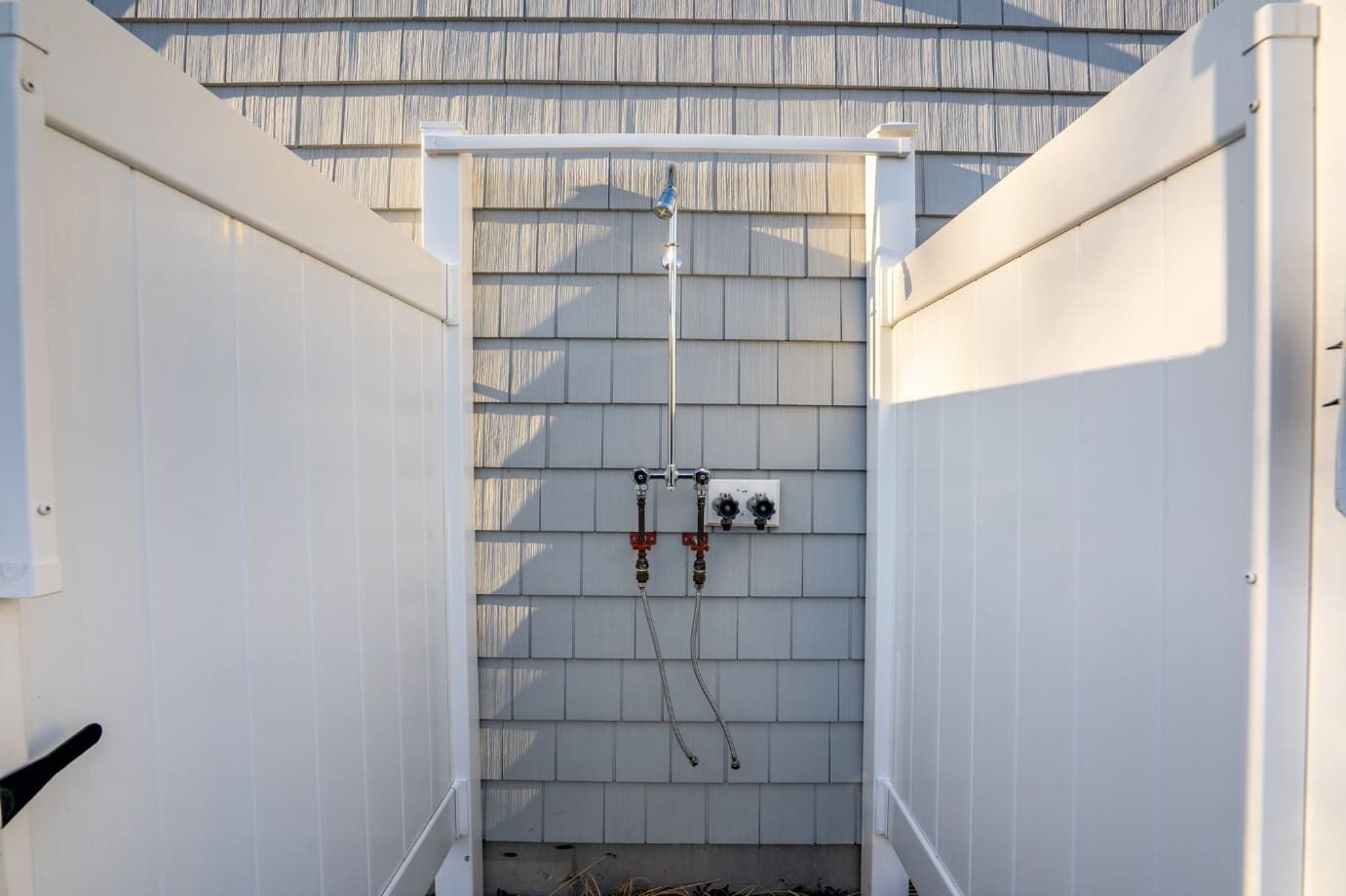 An outdoor utility area with electrical panels and pipes.