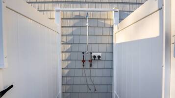 An outdoor utility area with electrical panels and pipes.