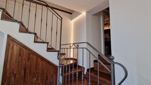 A wooden staircase with a metal railing and a wooden door at the bottom.