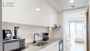 Une cuisine moderne équipée d’un four à micro-ondes, d’une machine à café, d’un évier et d’un lave-vaisselle.