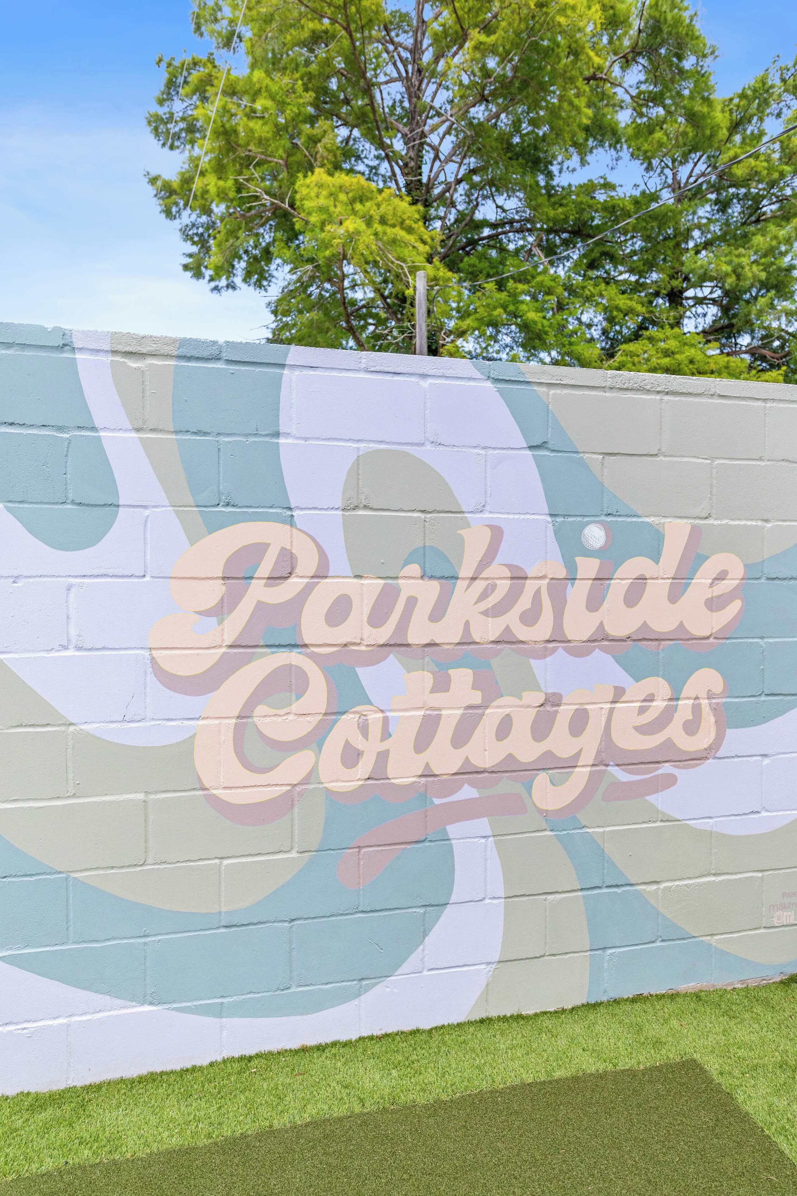 A wall with the text "Parkside Cottages" in a stylized font.