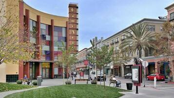 A multi-story building with a prominent 'CINEMA' sign, surrounded by a pedestrian area with benches and trees.