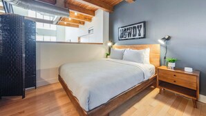A bedroom with a bed, wooden nightstand, and a wall-mounted sign. - Santana Row Properties #9 - Silicon Valley Getaway: Escape the Ordinary! (San Jose)