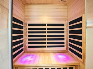 A sauna with wooden walls and a bench.