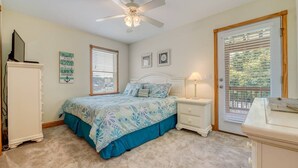 A bedroom with a bed, a nightstand, a dresser, a ceiling fan, and a window with blinds. - 3 BUOYS, 1 GULL - 5-bedroom house within walking distance to beach access (Kill Devil Hills)