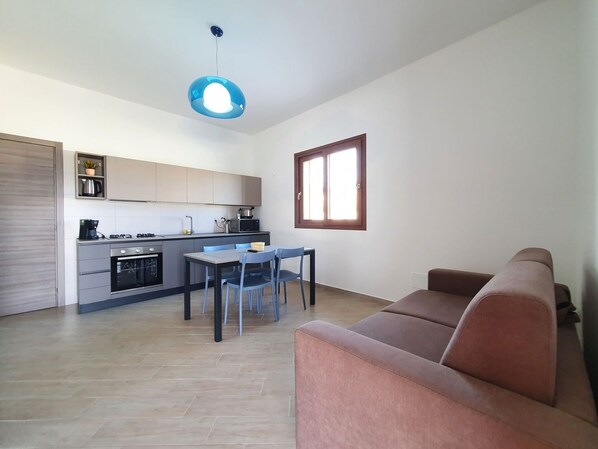 A modern kitchen with a dining area, a sofa, and a window. - Nice apartment for 6 guests with WIFI, pool, A/C, TV and terrace (Balestrate-foce)