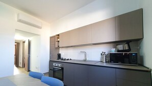 A modern kitchen with a built-in oven, microwave, and a coffee maker.