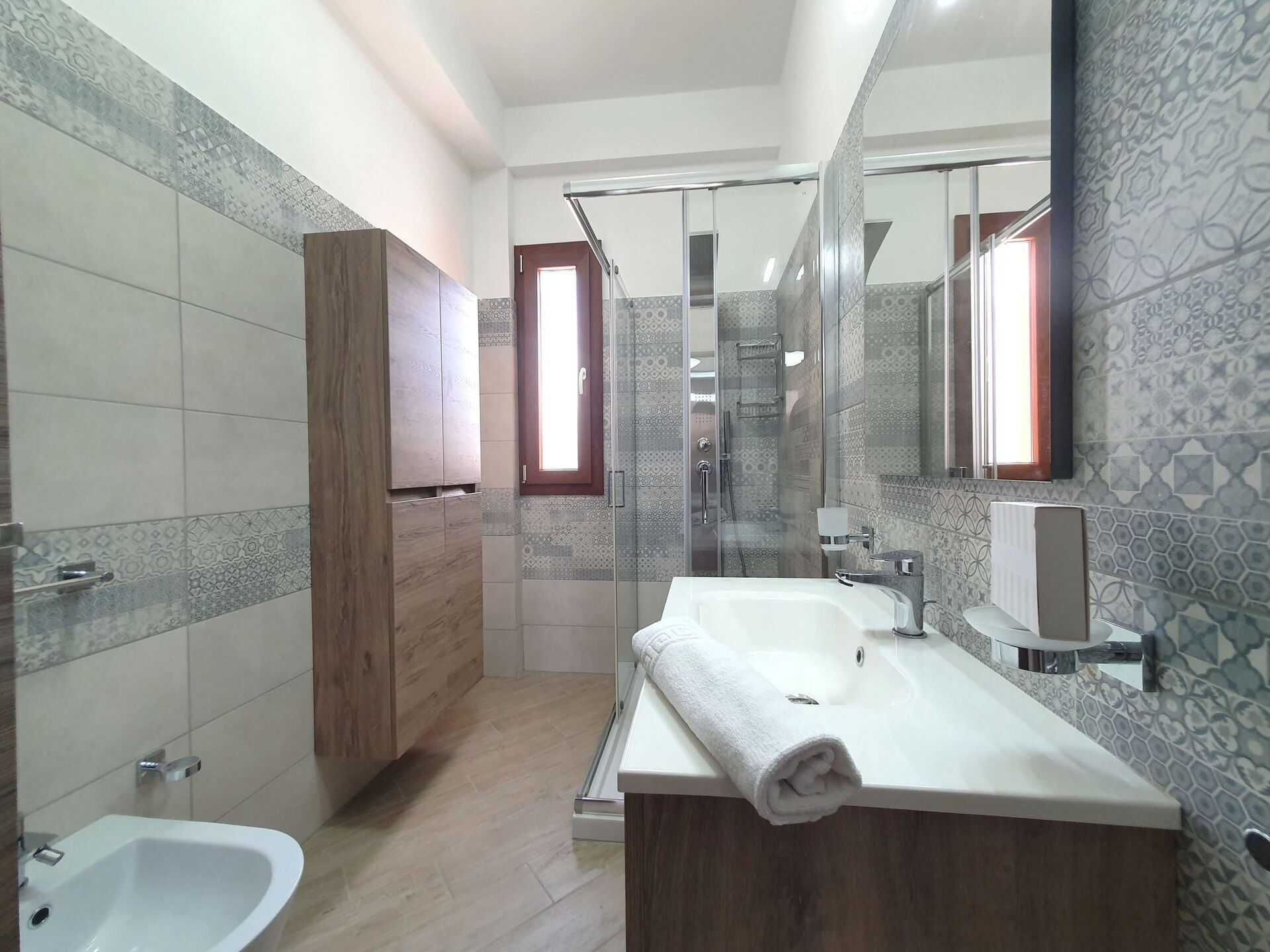 A modern bathroom with a shower, a sink, and a toilet.