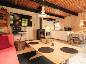 A cozy living room with a fireplace, a flat-screen TV, and a dining area with a table and chairs.