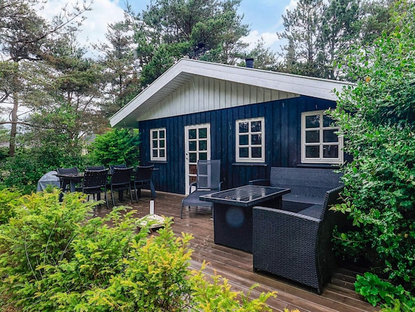 A blue house with a deck, outdoor furniture, and surrounding greenery. - 6 Person Holiday Home in Hals (Hals)