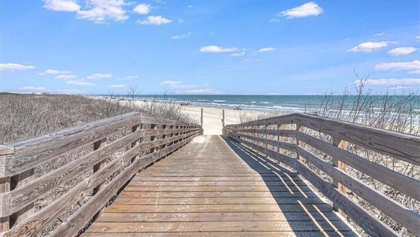 A wooden boardwalk leading to a beach with a clear sky. - FD186 Shared Pool, Pet Friendly, Golf Cart Included, Boardwalk to the Beach (Port Aransas)