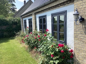 Une maison avec trois fenêtres et une façade en briques.