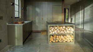 Una cocina moderna con encimera de mármol, armarios empotrados y una isla central con almacenaje de madera.