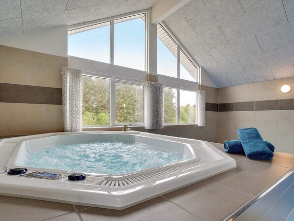Ein Whirlpool mit Blick auf Bäume, ein Handtuch und eine Steuerung.