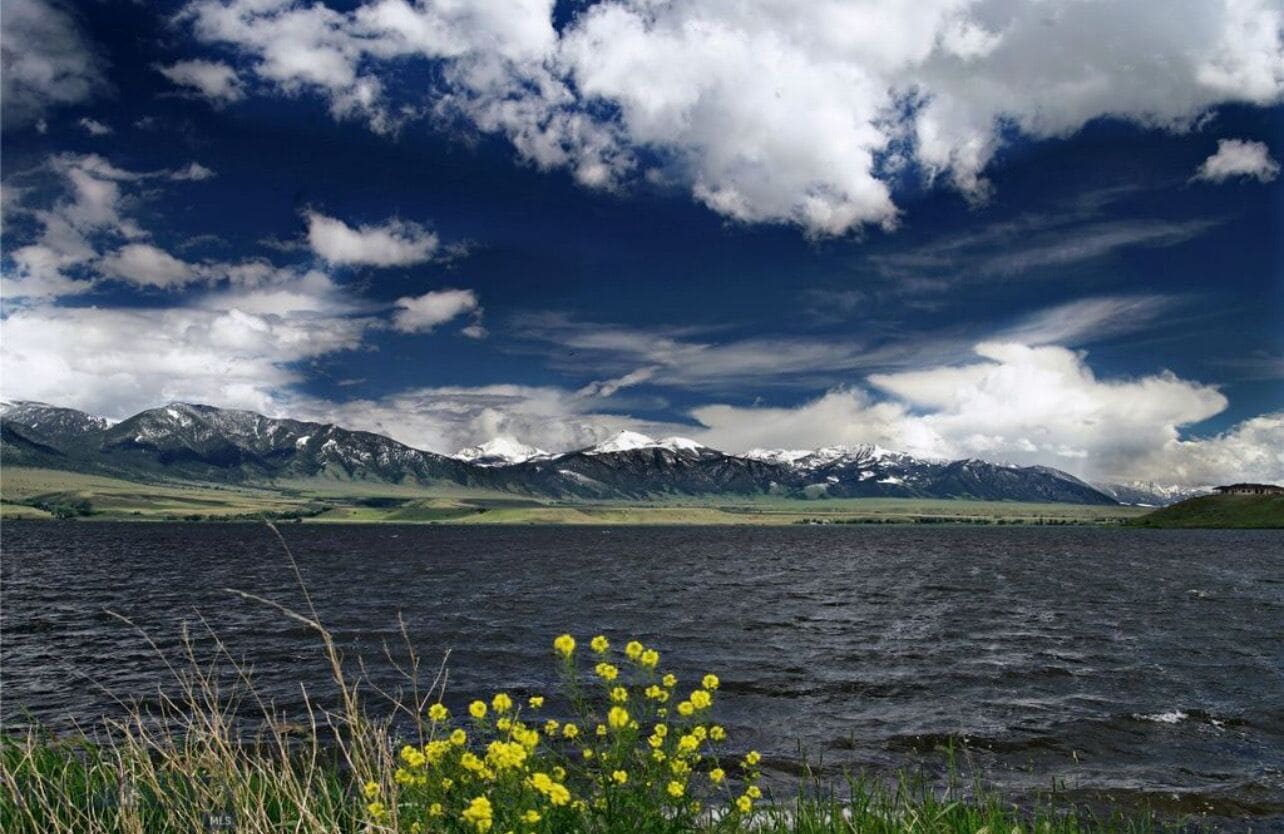A lake with mountains in the background and a clear sky.