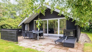 A modern outdoor patio with a dining table and chairs, a lounge area, and a covered seating space. - 4 Person Holiday Home in Hemmet (Hemmet)
