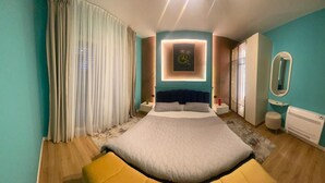 A modern bedroom with a large bed, a bedside table, a mirror, and a window with curtains. - city center 1-bedroom apartment with WiFi and AC in delightful Shkodër (Shkodër)