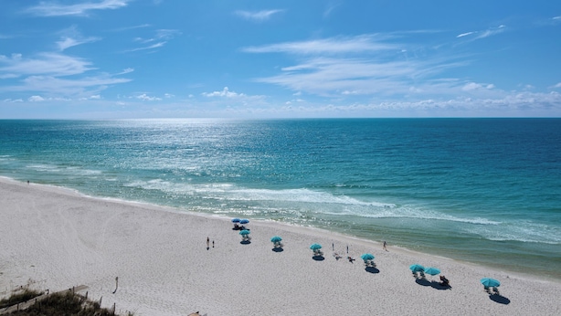 A beach with a clear sky, calm sea, and several umbrellas. - Sandy Key 816: 2 BR/2 BA Perdido Key Beachfront Condo, On-Site Rental Office, Sleeps 6 (Pensacola)