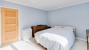 Una camera da letto con un letto, un armadio in legno, un termosifone e una porta.