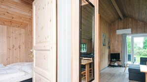 Un interior de madera con una cama, un escritorio y un televisor.