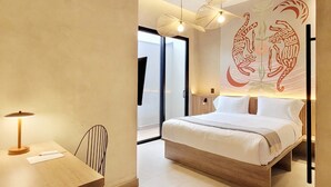 A modern hotel room with a large bed, a desk with a lamp, and a wall mural. - w Sophisticated 1BR w Terrace in El Poblado (Medellín)