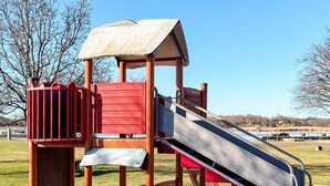 A playground with a slide, climbing area, and a covered playhouse. - 4 Star Holiday Home in Ronneby (Ronneby)