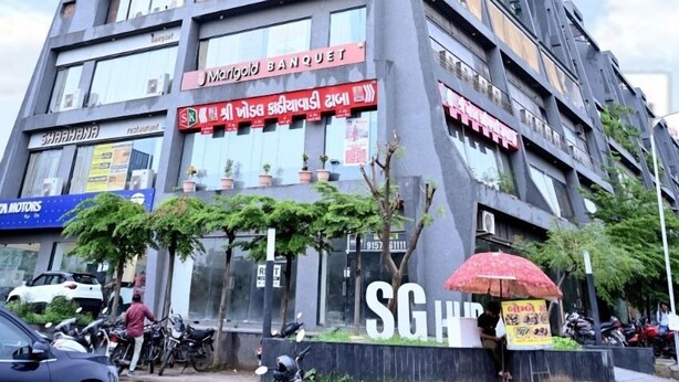 A multi-story building with various signs, including a hotel and restaurant. - Hotel Lavit (Ahmedabad)