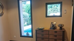 Un dormitorio con una cama grande, dos ventanas, un tocador y una alfombra.