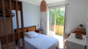 A bedroom with a bed, bedside table, lamp, and a view of the outdoors. - 1.5 km from "plage de la Garde" Top of Villa with private garden and barbecue area (La Garde)