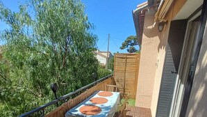 A patio with a table and chairs, a wooden fence, and a brick floor. - 1.5 km from "plage de la Garde" Top of Villa with private garden and barbecue area (La Garde)