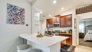 A modern kitchen with a central island, wooden cabinets, and a stainless steel microwave. - 6 Mi to Beach: Family Oasis w/ Pool in Cape Coral (Cape Coral)