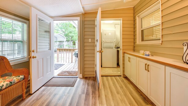 A kitchen with wooden cabinets, a countertop, and a door leading to a laundry area. - Fish, Relax & Repeat: Home w/ Yard in Eastpoint! (Eastpoint)