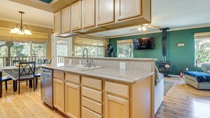 A spacious kitchen with wooden cabinets, a granite countertop, and a built-in dishwasher. - Furnished Deck & Mountain Views: Panguitch Cabin (Panguitch)
