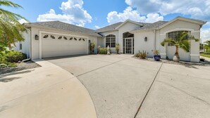 A single-story house with a garage, a covered entryway, and a driveway. - 12 Mi to Gulf: Port Charlotte Home w/ Boat Dock (Port Charlotte)