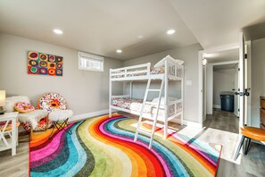 A child's room with bunk beds, a colorful rug, and a wall art piece. - 3 Mi to Dtwn: Family Home w/ Garden & EV Charger (Yakima)