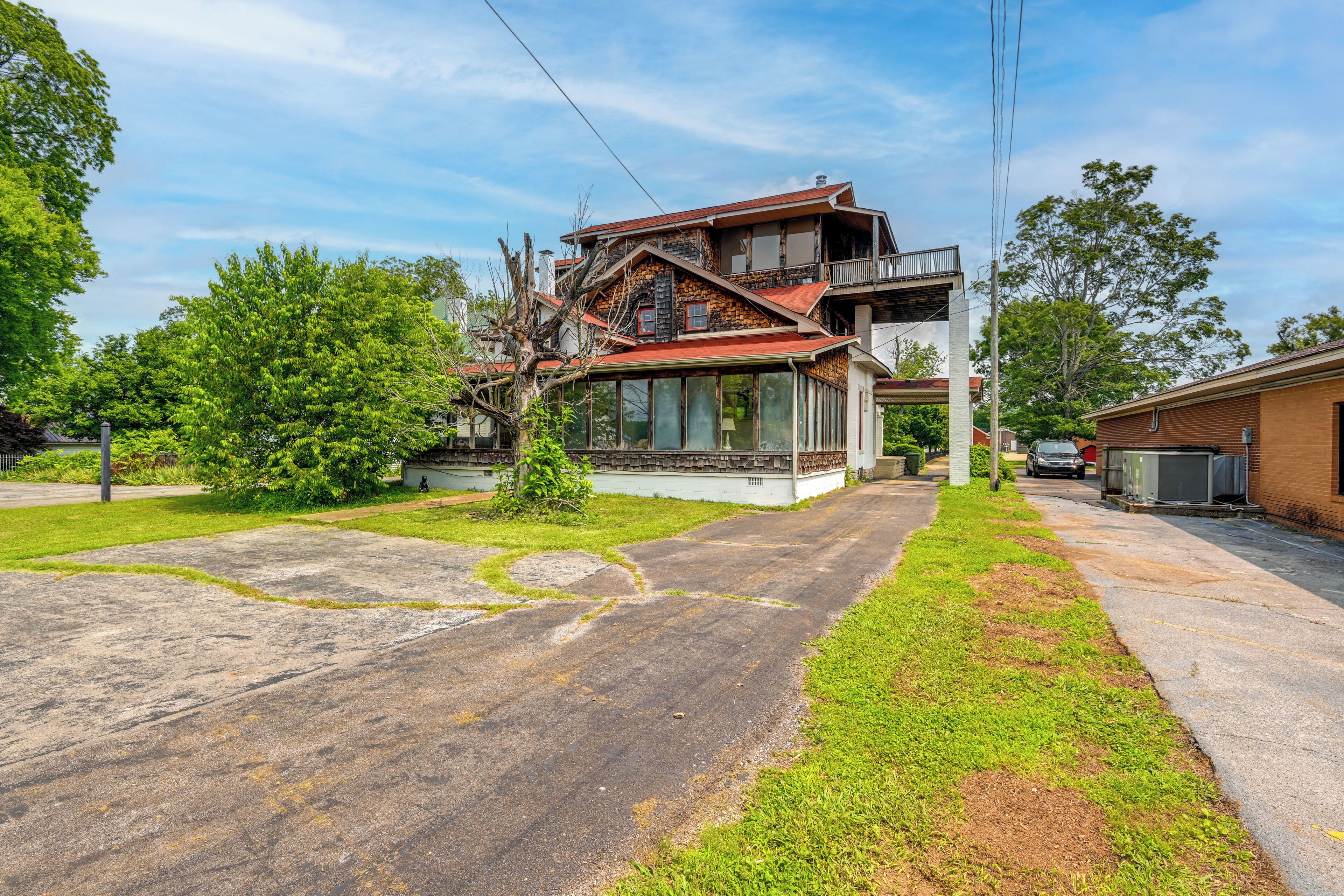 A two-story house with a balcony, a garage, and a driveway.