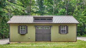 A small, single-story building with a metal roof, two windows with shutters, and a central door. - 1 Mi to Lake: Charming Byrdstown Retreat w/ Deck! (Byrdstown)