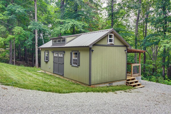 A small, single-story wooden structure with a sloped roof, a front door, and a small porch area. - 1 Mi to Lake: Charming Byrdstown Retreat w/ Deck! (Byrdstown)