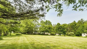 A well-maintained grassy lawn with trees and a house in the background. - Peaceful Country Retreat: Private & Convenient (Frenchtown)