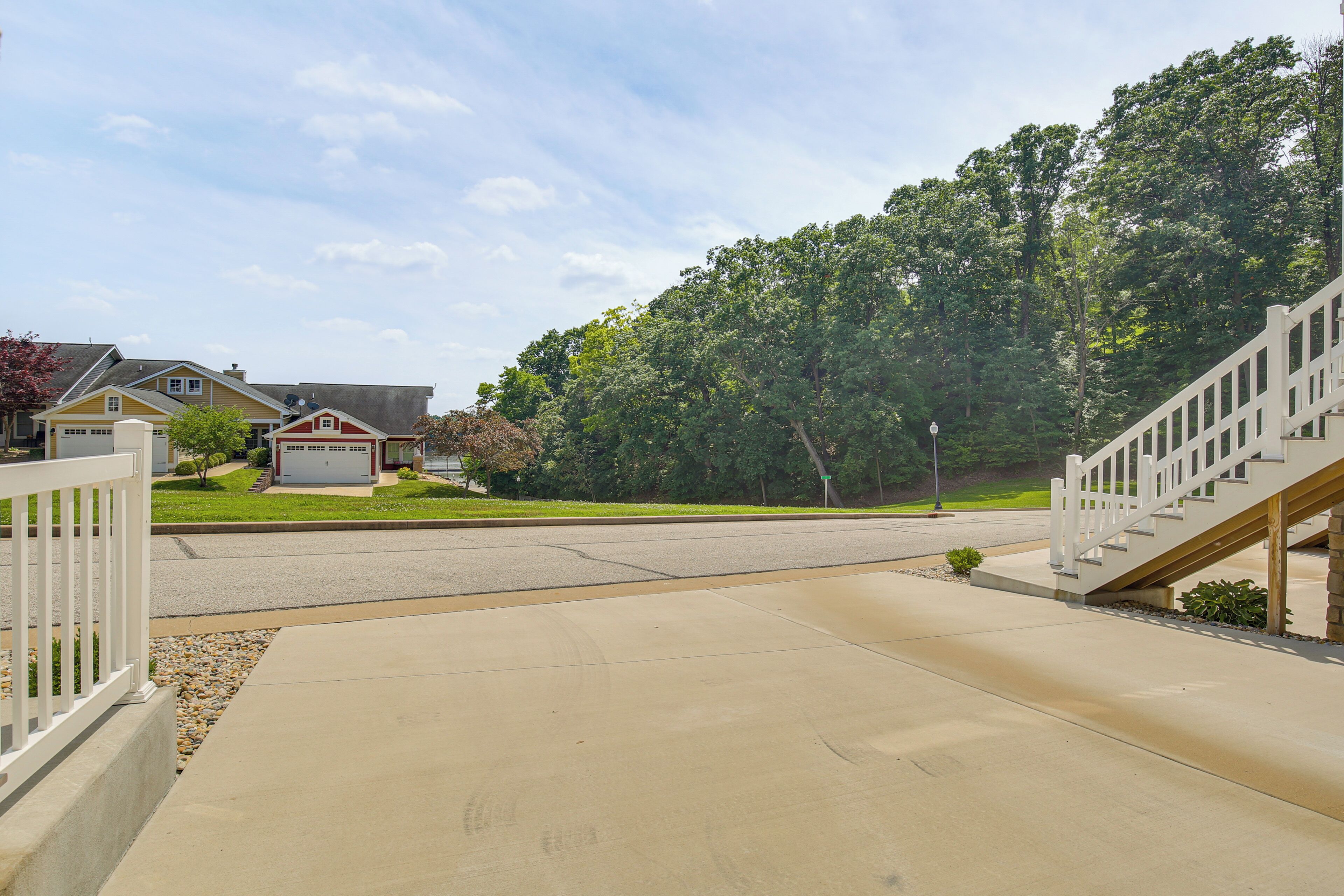 A residential driveway with a concrete path leading to a house with a garage.