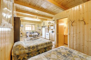 Un accogliente chalet con due letti, una cucina, una sala da pranzo e un soggiorno.
