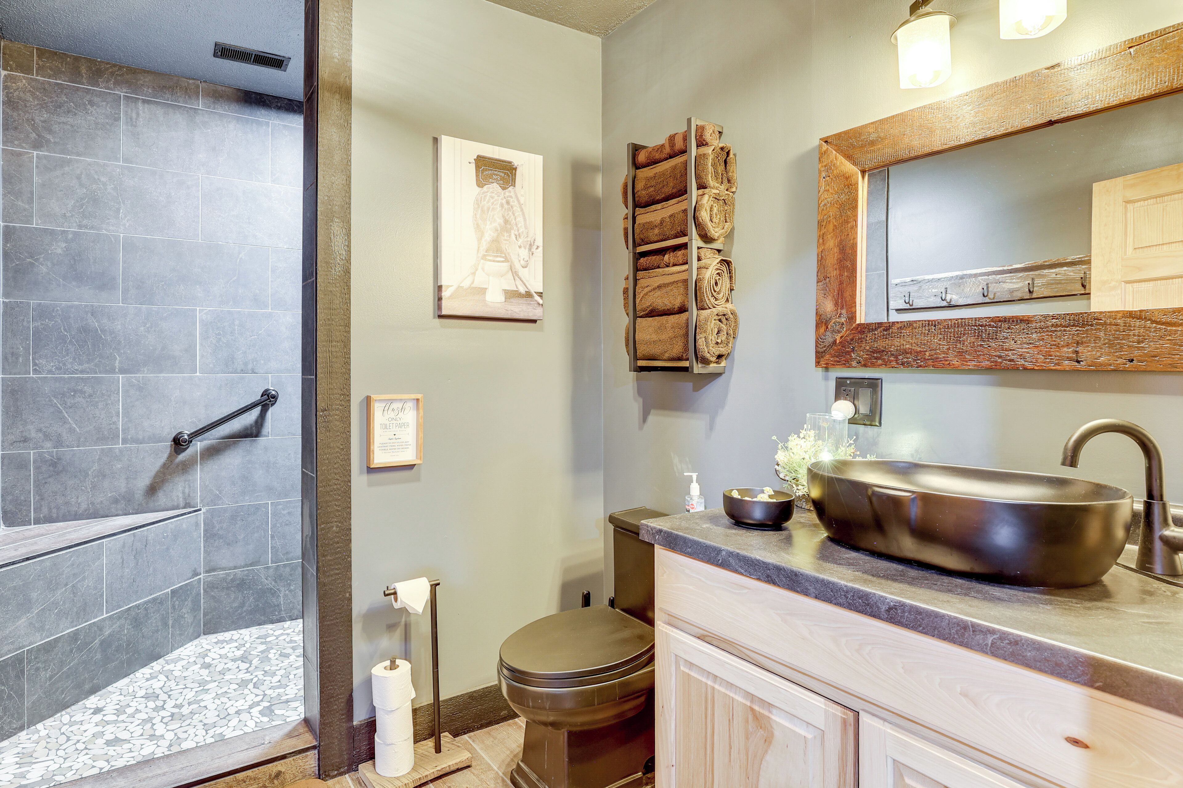 A bathroom with a shower, toilet, sink, and towel rack.