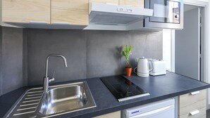 A modern kitchen with a stainless steel sink, a built-in stove, and a dishwasher. - Appart'hotel Cannes Sun (Cannes)