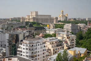A cityscape with historic buildings and modern architecture, including a prominent government building with golden domes. - Views of all the Palaces 2BR Stunner (Bucharest)