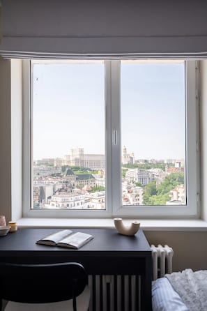 A room with a large window, a desk, a chair, and a radiator. - Views of all the Palaces 2BR Stunner (Bucharest)