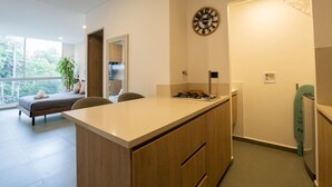 Una cocina moderna con encimera de madera, estufa integrada y un reloj de pared.