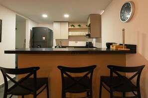 Fridge, microwave, coffee/tea maker, cookware/dishes/utensils